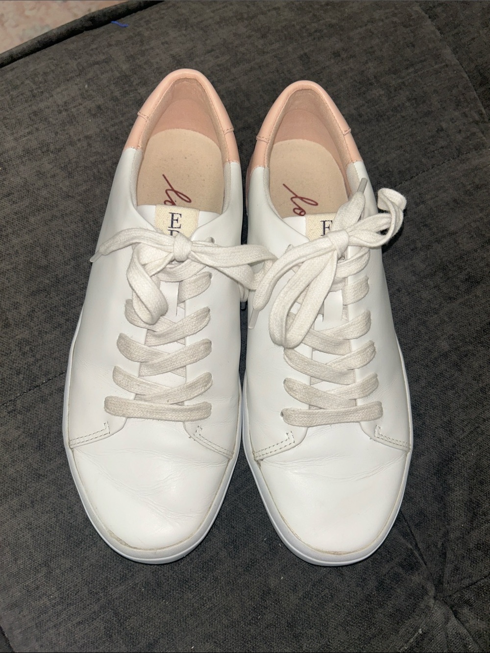 Ellen Degeneres blush and white leather sneakers.
